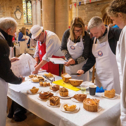Competition at pie week, pies being judged on the table