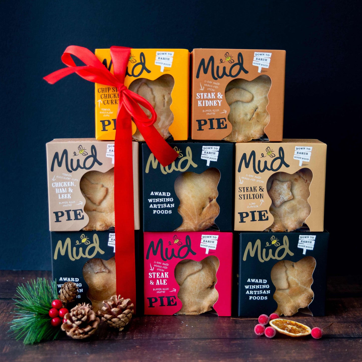 The Mud Pies Ultimate Christmas box holds 8 artisan pies, like Christmas in a Pie, in colourful boxes with a red festive ribbon.