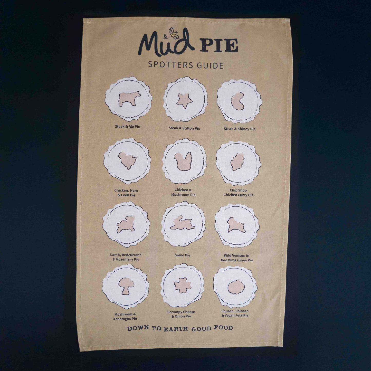The Mud Pies Tea Towel Pie Spotters Guide is a beige, pure cotton towel with twelve outlined pies and “Down to Earth Good Food.”.