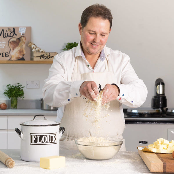 A man mixing flour and butter to make pastry