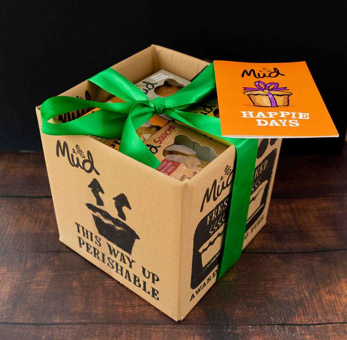 Mud Pies Best Ever Veggie Gift Box: a “THIS WAY UP PERISHABLE” carton on wood, tied with green ribbon, showing eggs inside.