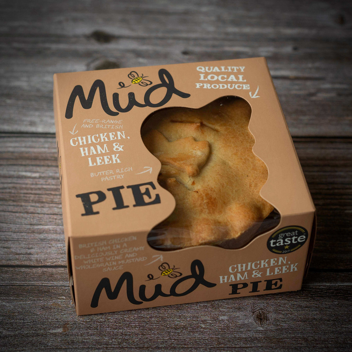 A golden-brown handmade Mud Pies Best Sellers Christmas Pie Gift Box in a windowed cardboard box, labeled Chicken, Ham Leek with ingredient details, a Great Taste award logo, and the text Christmas In A Pie.