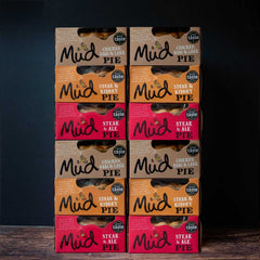 Mud Pies Best Sellers Pie Box: twelve pies stacked, orange Chicken Ham Leek above red Steak Ale, each with a Great Taste badge on a dark background.