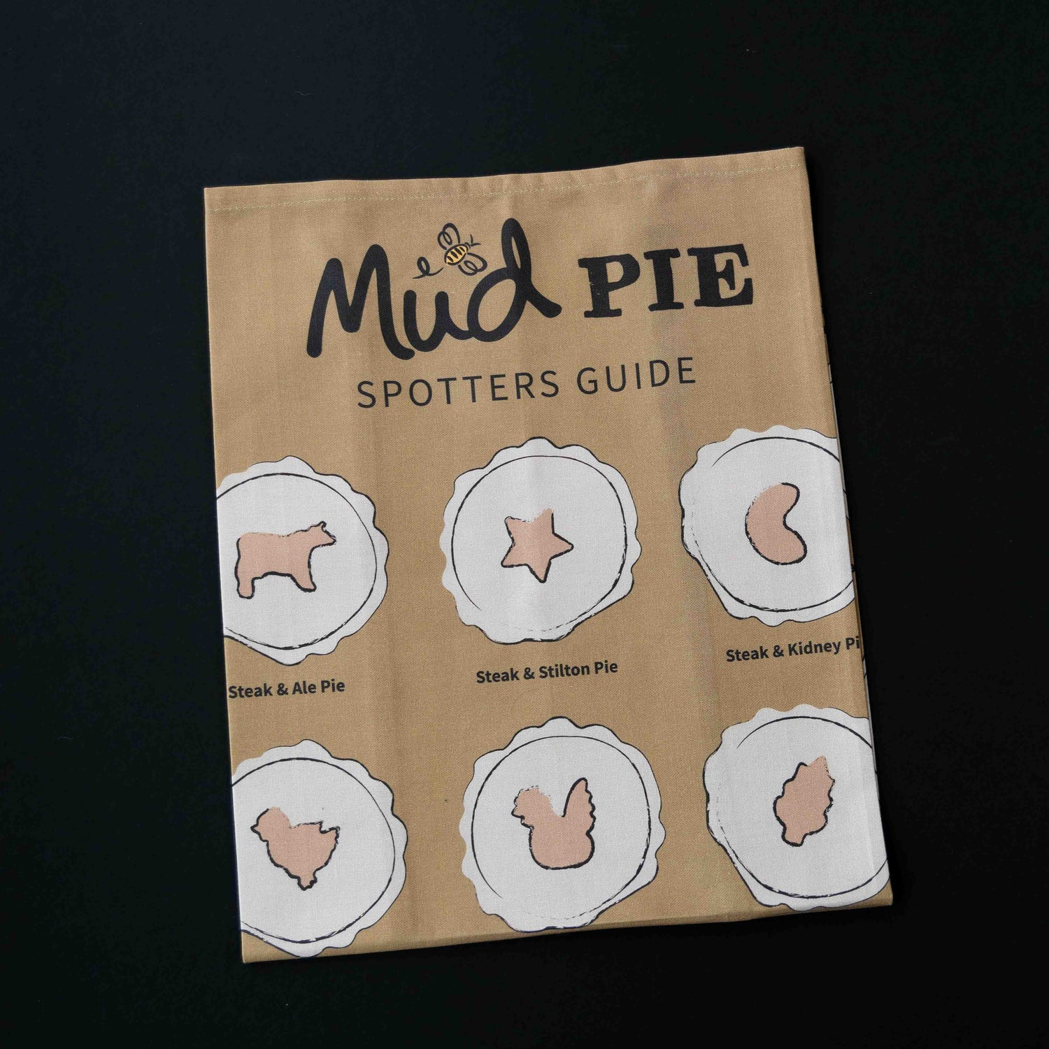 The Mud Pies Tea Towel Pie Spotters Guide is a plush cotton towel featuring detailed pie illustrations on a deep, rich background.