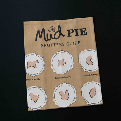 The Mud Pies Tea Towel Pie Spotters Guide is a plush cotton towel featuring detailed pie illustrations on a deep, rich background.