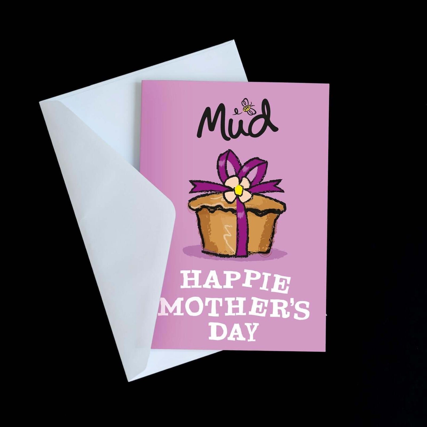 The Mother’s Day Greetings Card by Mud Pies shows “Mud” at the top, a cartoon cupcake with a purple ribbon, yellow flower, and bold “HAPPIE MOTHERS DAY” text. Presented in a white envelope.