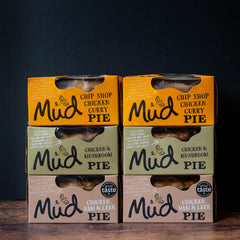 Six Mud Pies Chicken Pie Box 6 Pack, with Chip Shop Chicken Curry, Chicken Mushroom, and Chicken Ham Leek pies stacked in two neat columns on a dark background.