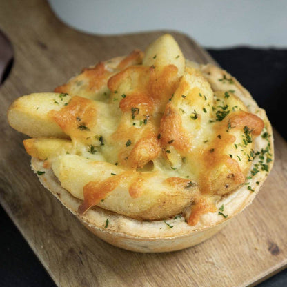 Mud Pies Chip Top Steak Royale is a golden-brown British pie, topped with chunky chips, gooey cheese, and fresh herbs.